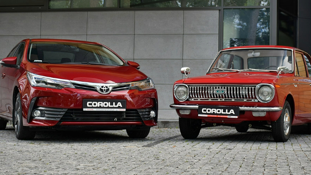 A recent-model red Toyota Corolla parked next to an early-model red Toyota Corolla