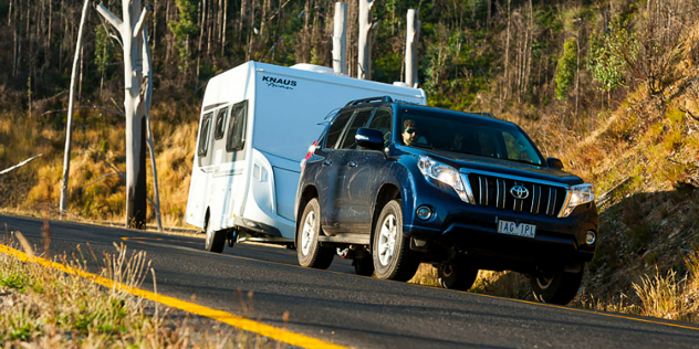 Prado towing a caravan along a country road