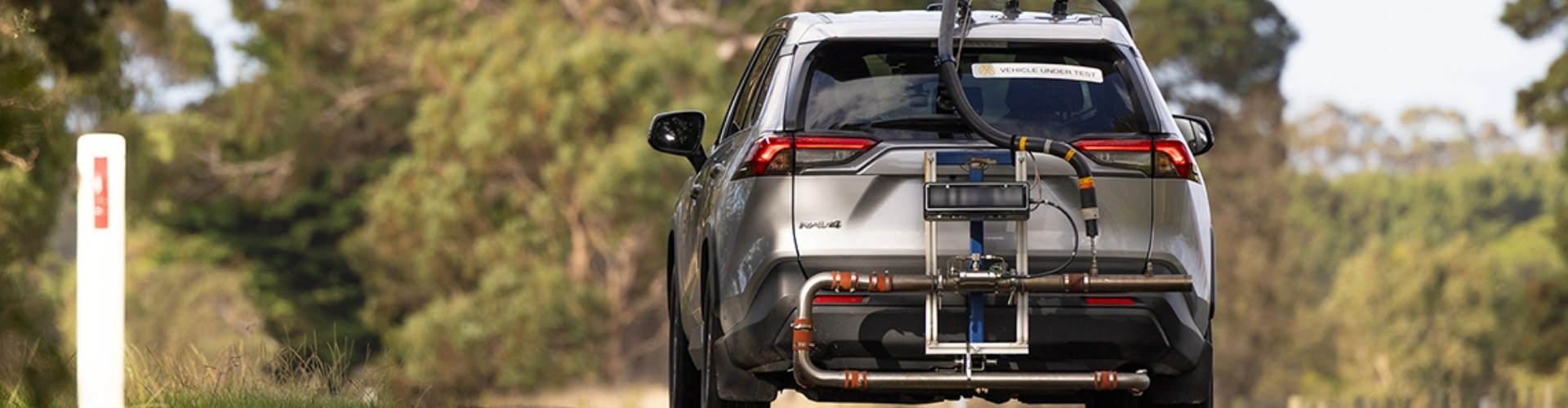 Rear view of a Toyota Rav 4 driving along a road.