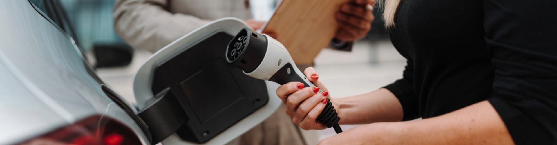 Someone inspecting an electric vehicle charge plug