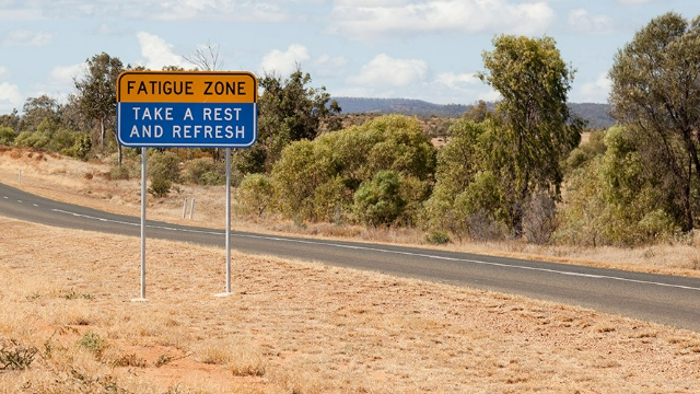Roadside sign on a country road encouraging drivers to take a break