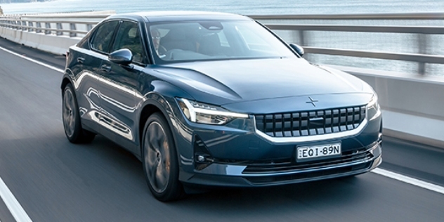 A Polestar 2 Long Range Dual Motor drives along a coastal highway