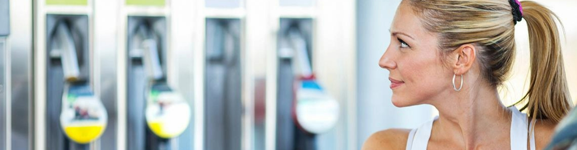 Woman looking at a fuel pump Woman looking at a fuel pump