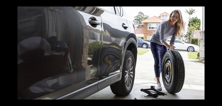 Woman maintaining car tyres at home