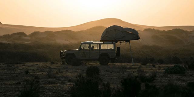 4WD setting up camp overlooking the sand dunes near Mungo National Park.