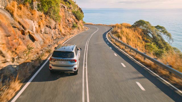 Car driving on road between Cairns and Port Douglas near Rex Lookout