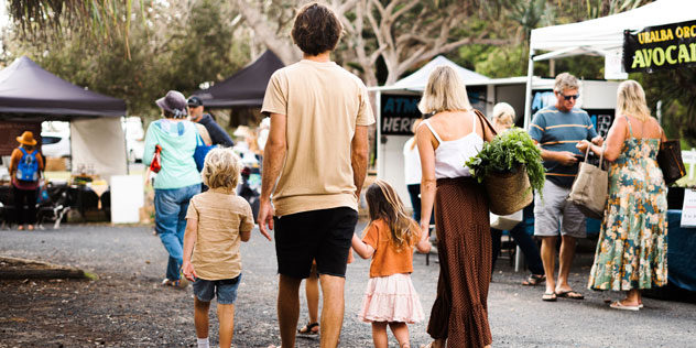 Family wandering through a farmers market in Yamba