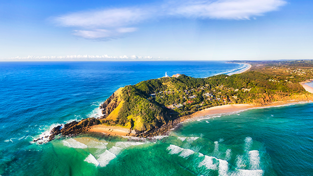 Byron bay and famous lighthouse on the top of headland facing Pacific ocean - the most eastern part of Australian continent.