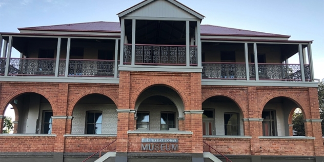 heritage, two storey brick building with arched windows on wide veranda