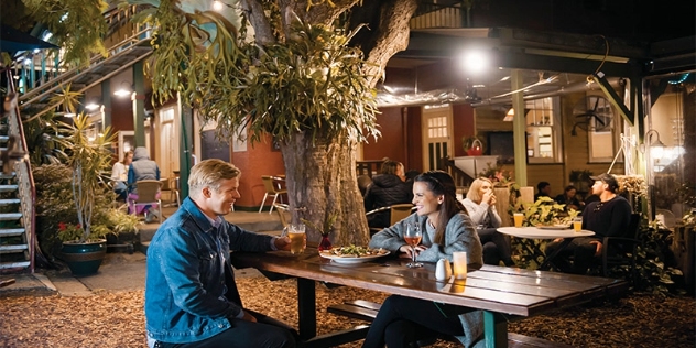 couple enjoying a meal at a picnic table in the hotel gardens