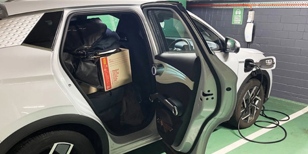 electric vehicle plugged into a discreet charger in an allocated parking space in the basement of a building