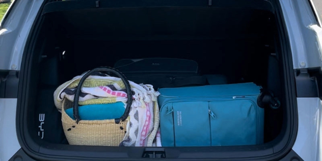 open boot showing one large and one small bag plus a heavily loaded beach bag with additional available space