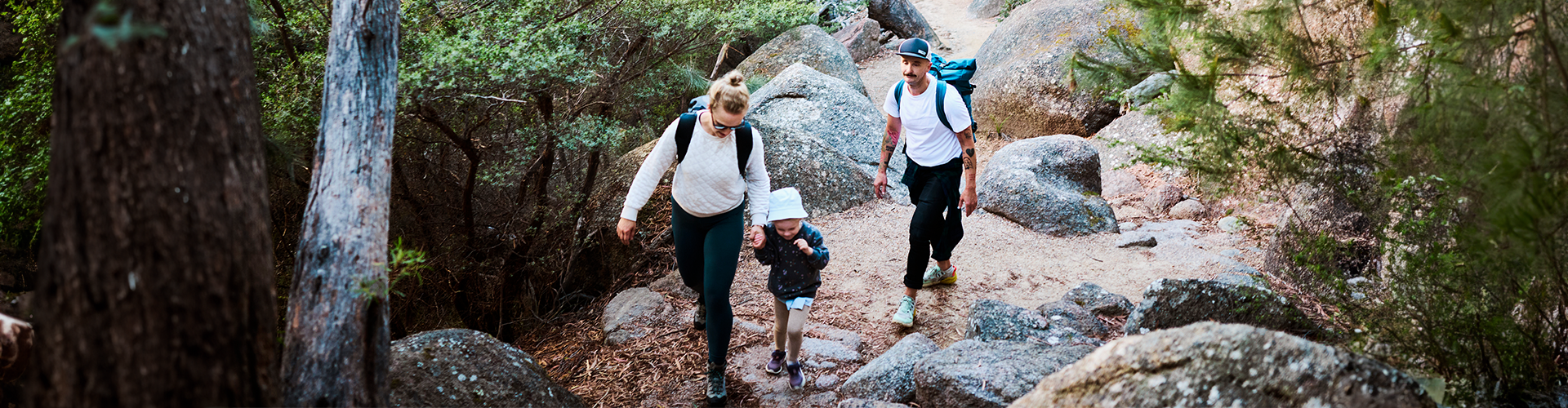 Family on a bushwalk through rocks and trees