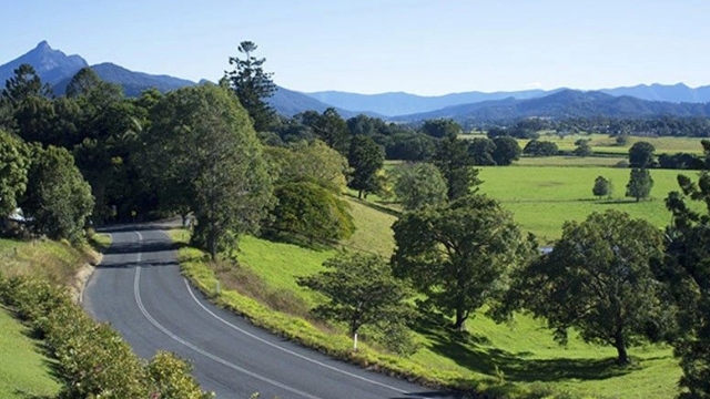 Winding road through the green fields of the Gold coast Hinterland on a sunny day