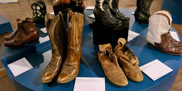 circular table displaying 8 pairs of cowboy boots once owned by Slim Dusty