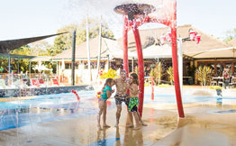 Kids playing in water fun area at pool