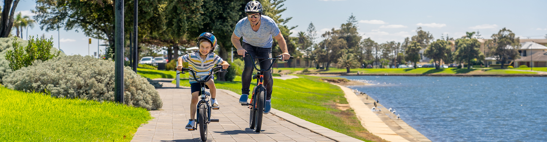 Dad and son ride bikes along the water