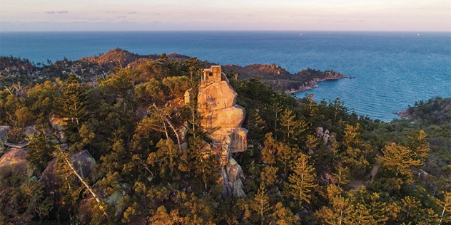 arial view of sunset on rocky peaks and coastline with the sea in the background