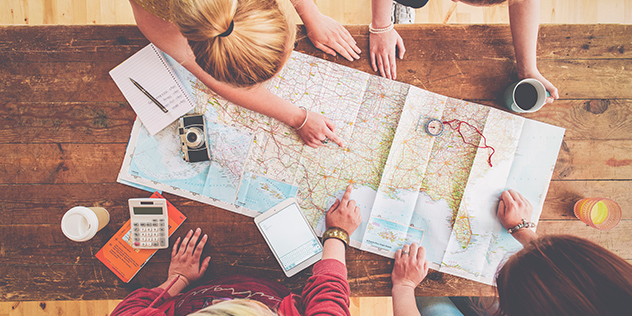 People travel planning around a map