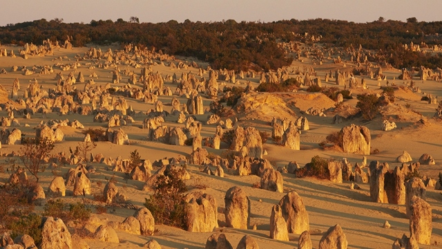 unusual limestone rounded rocks protrude from desert sand