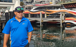 Ferry staff in blue shirt in front of NRMA ferry
